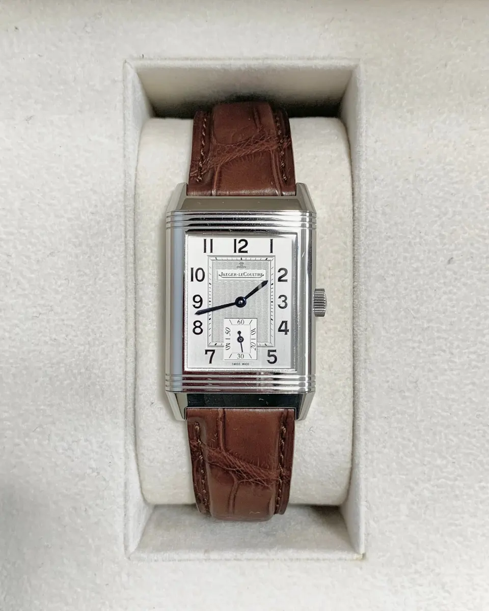 Steel Jaeger-LeCoultre Reverso on a brown alligator strap, sitting in its white presentation box — stand-in photograph